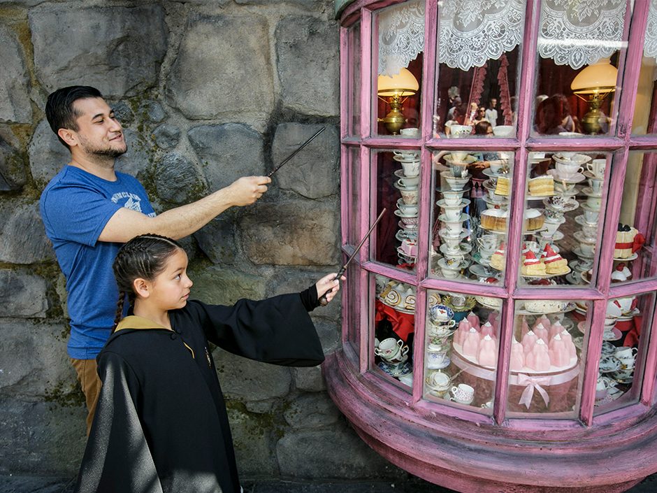 Dad and daughter using interactive wands at Harry Potter World