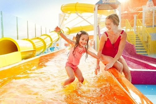 girl playing in waterworks with her mom on a carnival cruise ship 
