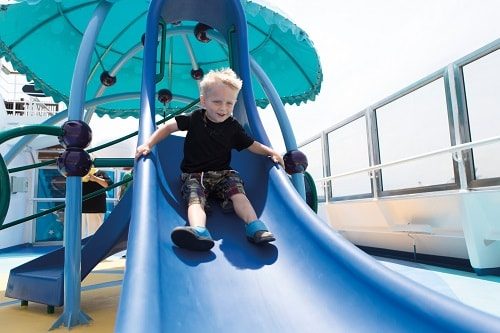 boy sliding down a slide in camp ocean 