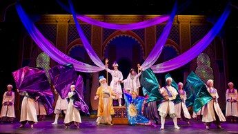 Aladdin, Jasmine, the Sultan and Magic Carpet are joined by an ensemble of palace guards waving fabric